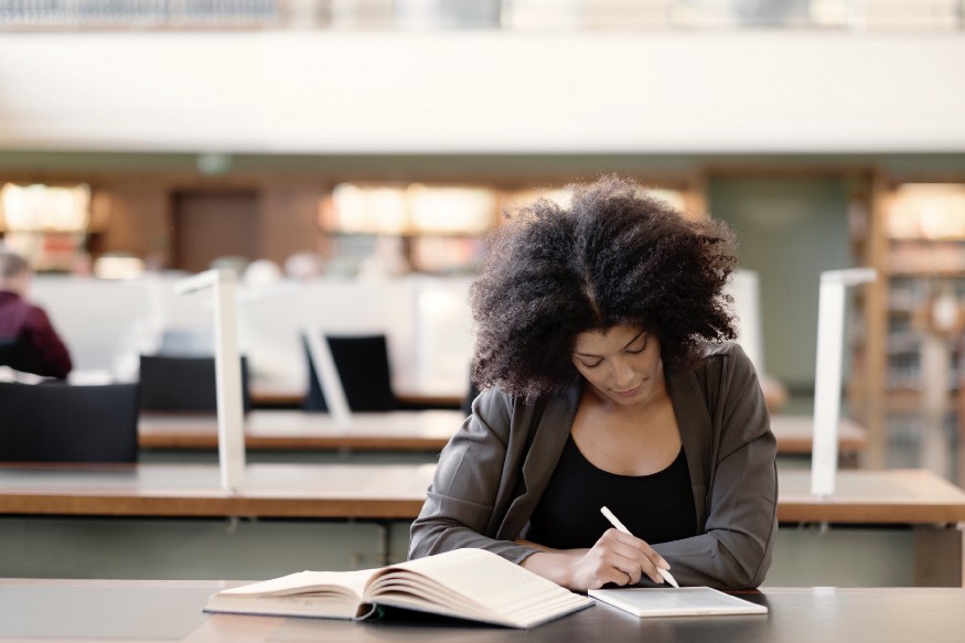 Taking notes and writing on paper is shown in this image